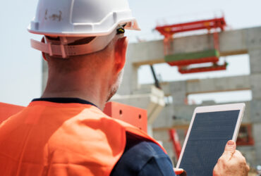 Engineer reviewing site plans and elevation levels before building permit approval