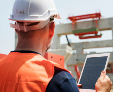 Engineer reviewing site plans and elevation levels before building permit approval