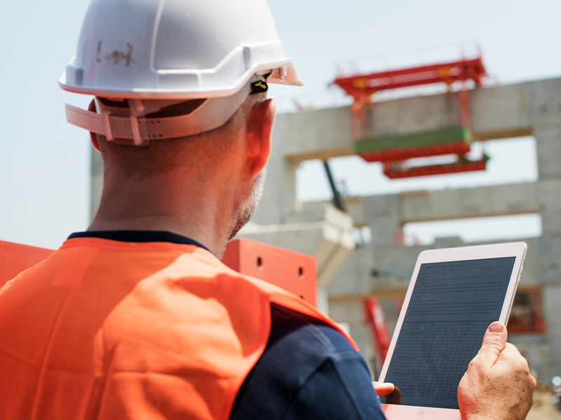 Engineer reviewing site plans and elevation levels before building permit approval